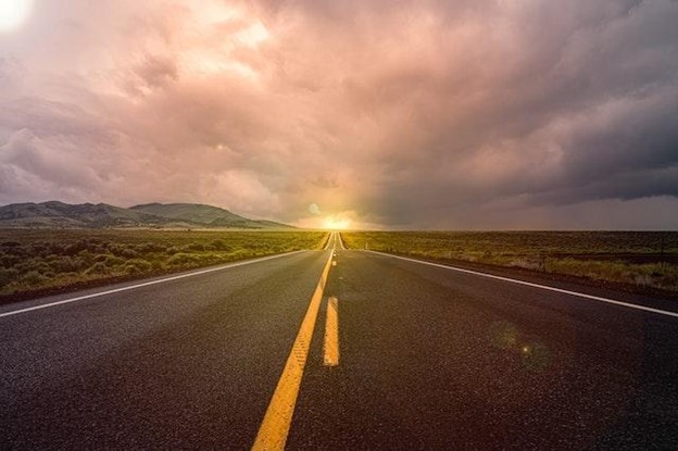 A long highway road at sunset.