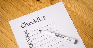 A checklist on the desk and a black marker to help you overcome the fear of unknown when moving