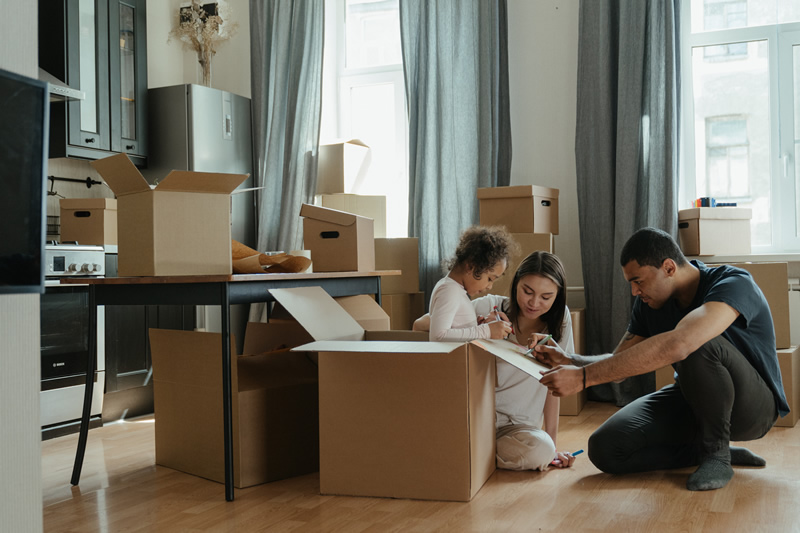 A family packing their kitchen for relocation.