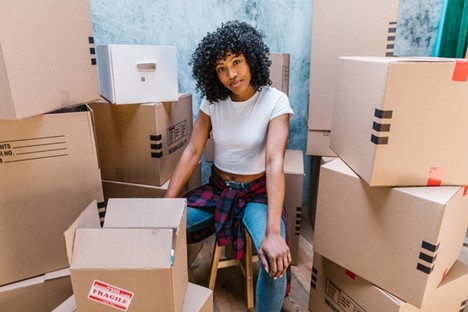 A woman surrounded by cardboard boxes.